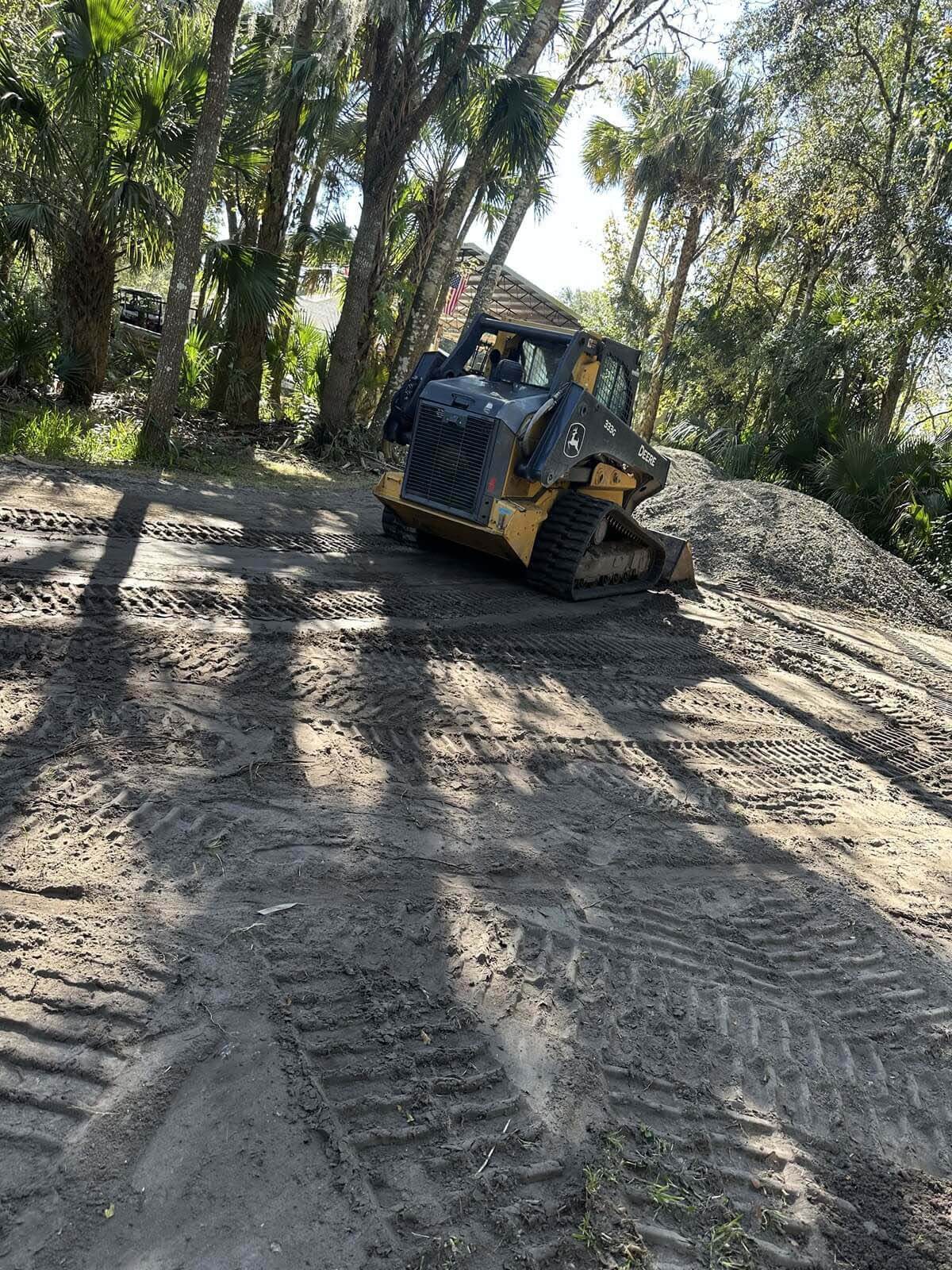 A skid-steer loader leveling cleared land for construction preparation.