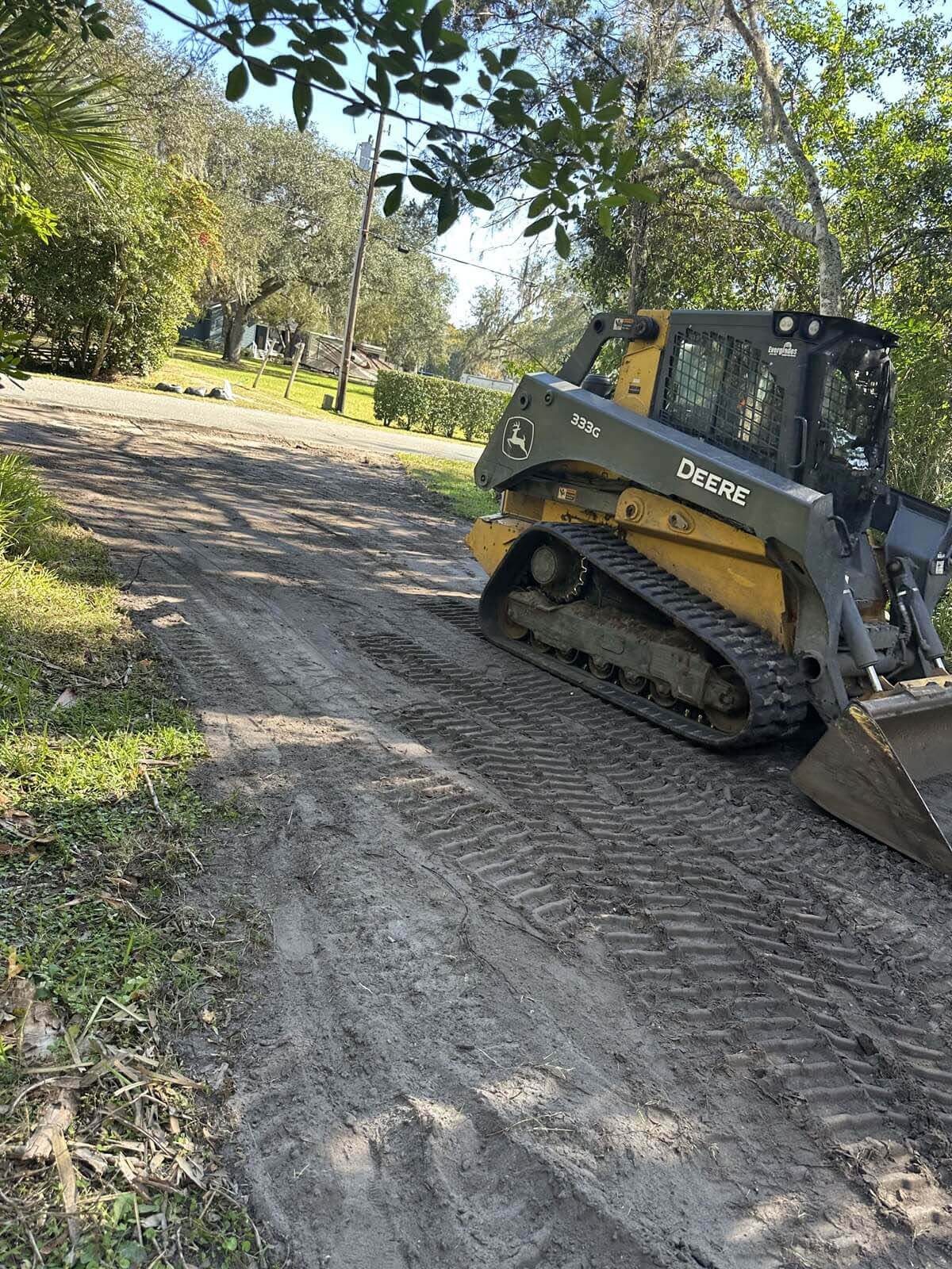 Heavy equipment clearing brush and leveling land for site preparation.